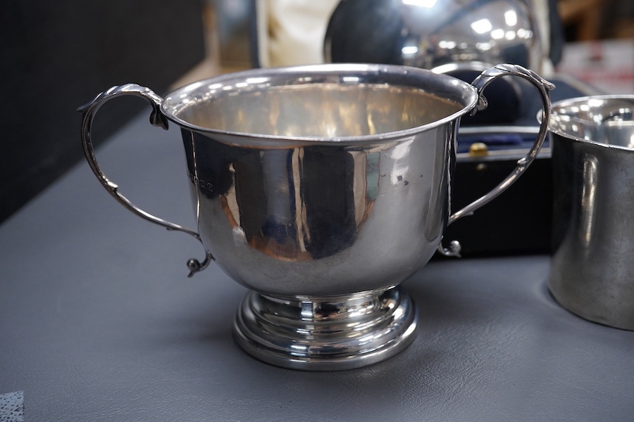A George V Britannia standard silver mug, by Thomas Bradbury & Sons, Sheffield 1918, height 65mm, handle a.f., together with a 1930's silver porringer and a George V cased silver christening bowl and spoon, 13.2OZ.